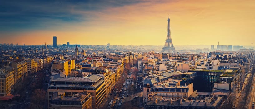 Sightseeing Paris panorama with view to the Eiffel Tower, France. Beautiful parisian cityscape sunset scene. Romantic view over rooftops of historic buildings and landmarks. Holiday destination