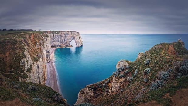 Idyllic panorama of Porte d'Aval natural arch at Etretat famous cliffs washed by Atlantic ocean, Normandy, France. Sightseeing coastline scenery, beautiful natural bay with sand beach