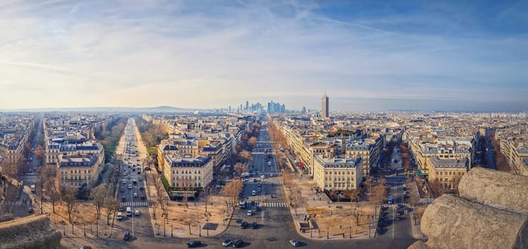 Wide angle Paris cityscape with view to La Defense metropolitan district, France. Beautiful parisian architecture with historic buildings, landmarks and busy city streets with car traffic