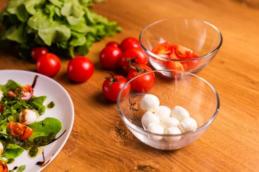Bowl of small mozzarella balls with tomatoes in kitchen