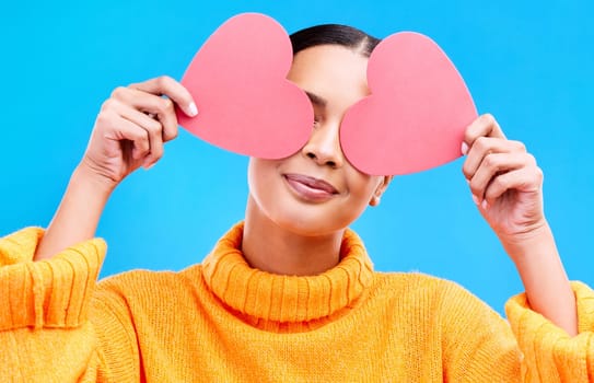 Heart eyes, cover and woman smile with happiness and excited for love, valentines day or studio emoji. Happy, loving or person on isolated blue background, creative romance paper and show care symbol