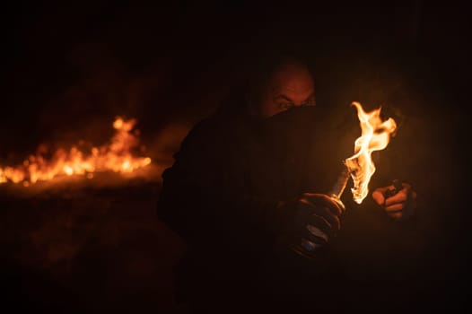 A masked man is holding a burning bottle. Molotov cocktail.