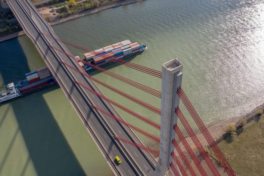 A Bridge Spanning a River with a Container Ship Moving Cargo