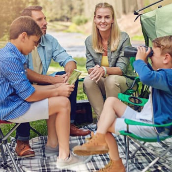 Enjoying their time outdoors. a family of four camping in the woods.