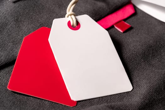 A closeup shot of white red clothing tags on a string with copy space