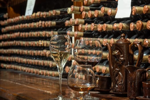 A closeup of bottles of different types of wine with a wine cellar in the background. Wine tasting