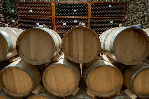 The wooden wine barrels with a wine cellar in the background