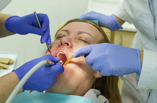 The dentist treats the teeth of the patient in the clinic.