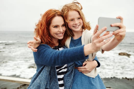 because every picture has a story to tell. a mother and her young daughter taking a selfie at the waterfront.