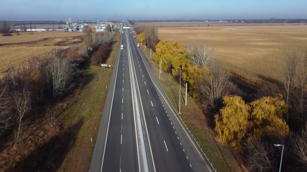 Cars driving along highway on autumn sunny day. Automobile road with markings