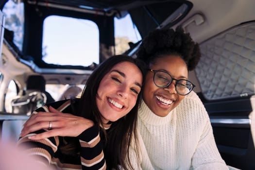 two women having fun taking a selfie in camper van