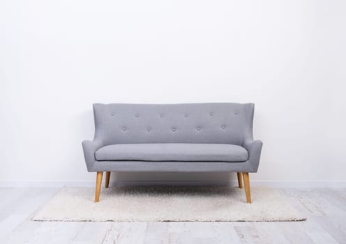 Gray sofa on carpet in light room