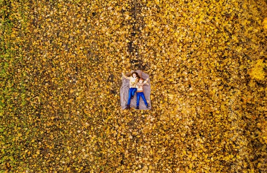 Sisters lying on yellow leaves