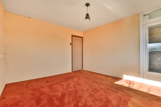 an empty room with a red carpet and a door