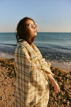portrait of a woman with a plaid on a warm, sunny, summer day on the beach