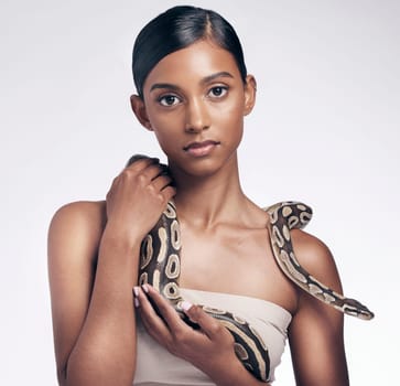 Beauty, portrait and woman in studio with snake on neck for art aesthetic with exotic zoo animal on white background. Face, skin and creative style, asian fashion model holding dangerous pet python