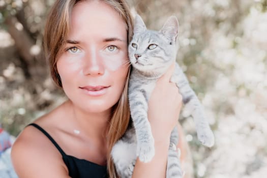 Woman summer travel cat. A woman on vacation with her pet cat enjoying a photo session on the beach. Travel and holiday concept.