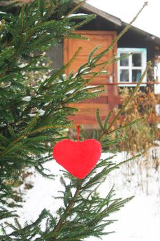 Decorative plush hearts on tree branch.