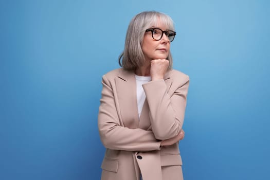 portrait of a hopeful middle-aged woman in a business outfit on a studio background with copy space