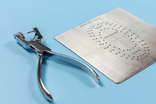 Dental hole punch and the metal plate on the blue.
