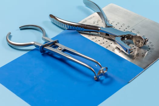 Dental hole punch, the rubber dam forceps and the metal plate.