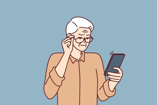 Elderly man with poor eyesight squint looking at screen of mobile phone to read SMS
