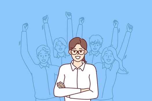 Woman leader standing with arms crossed near team located behind and making victorious wave of hands