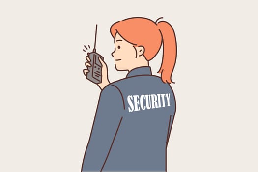 Woman security guard uses walkie-talkie to contact colleagues or report intruder