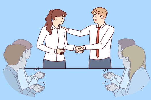 Handshake of boss and new employee of company during business meeting with colleagues