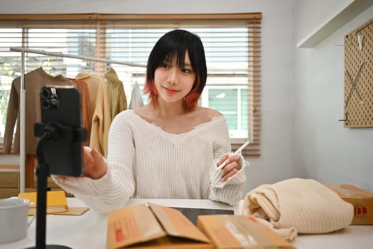 Young asian female small business owner in casual clothes and checking customer address or orders in an online store