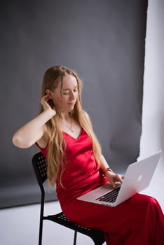 Woman blogger working to MacBook in photo studio