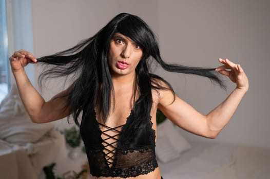 Gay man in wig and black lace lingerie.