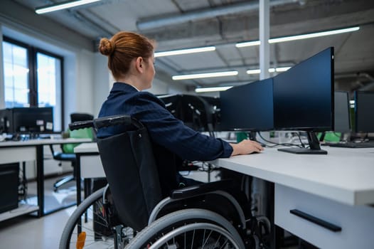Caucasian woman in wheelchair at work desk.