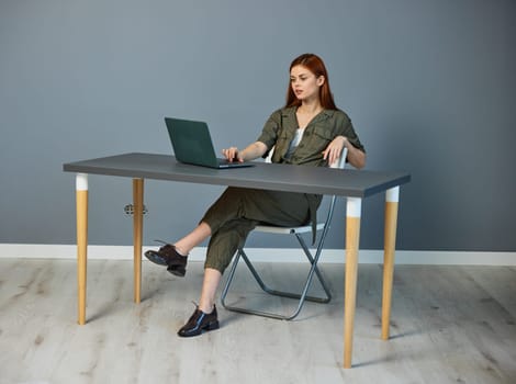 serious businesswoman working on a laptop while sitting at a table in the office
