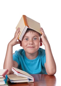 Child and books. The boy reads and plays with books. Delight on the face of the child from the books read. A preschooler is learning to read. Portrait of a boy on a white background