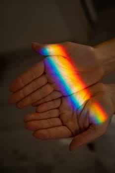 Rainbow ray on a woman's hand.