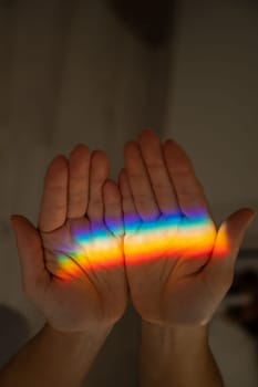 Rainbow ray on a woman's hand.