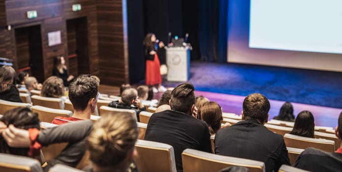 Woman giving presentation on business conference event.