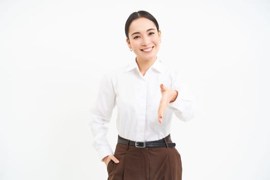 Confident asian businesswoman, extends her hand for handshake, greeting clients at company with friendly smile, white background
