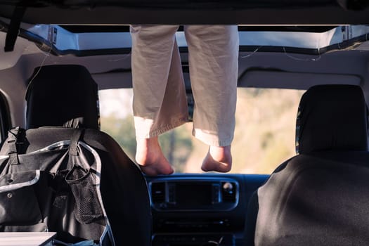 feet dangling off the elevated bed of a camper van