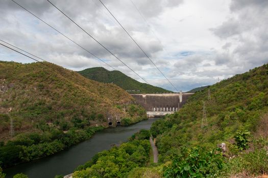 Image of front view of Bhumibol dam in Tak. Hydro Power Electric Dam and is the first multipurpose dam in thailand and is water storage for agriculture and electricity.. The curved concrete dam.