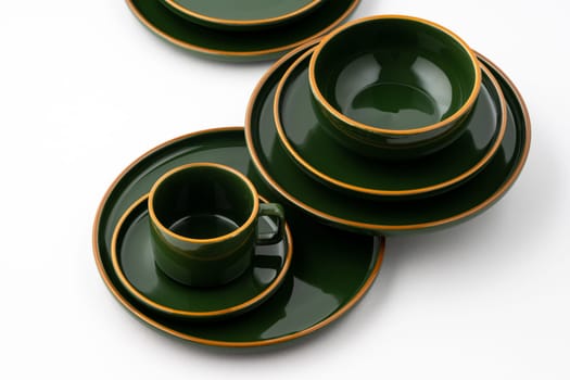 A set of dark green ceramic tableware with orange outlines
