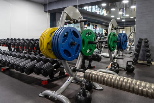 A closeup of weight plates and dumbbells in the sports complex