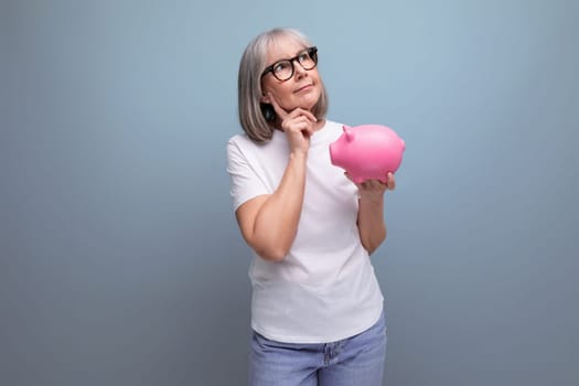 60s woman with gray hair thinks where to invest her savings on a studio background with copy space
