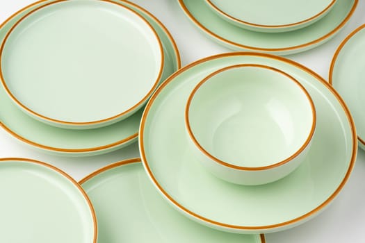 A set of pastel green ceramic tableware with orange outlines