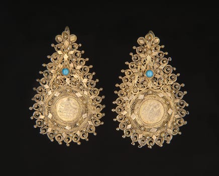 The vintage, central Asian earrings with precious stones isolated on a black background