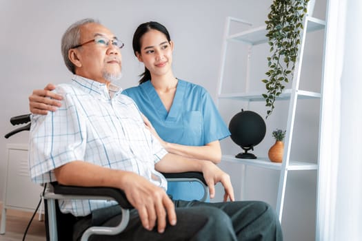 Caring nurse and a contented senior man in a wheel chair at home.