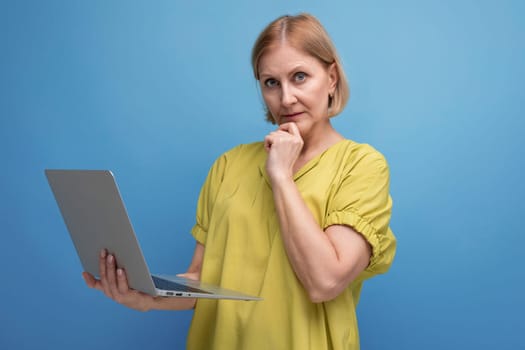 pensive middle aged business woman freelancing using laptop and internet connection