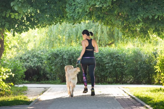 Girl running with golden retriever dog