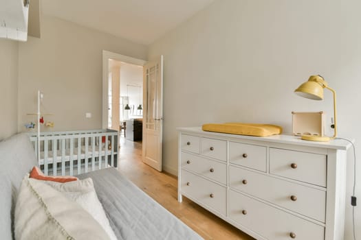 a nursery with a white dresser and a crib
